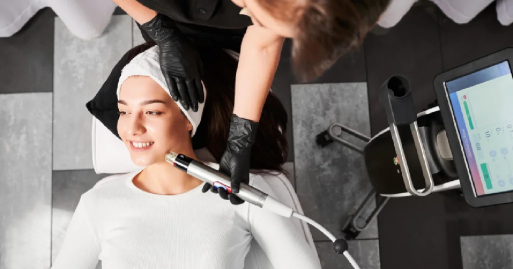 A woman receiving a facial treatment with a modern RF microneedling device in Palm Springs, CA